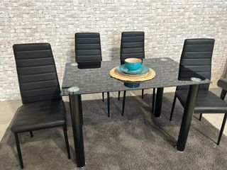 Mesa de cristal con 4 sillas negras
