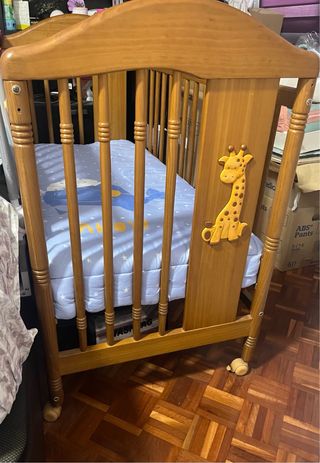 Cuna de madera con colchón y ropa de cama