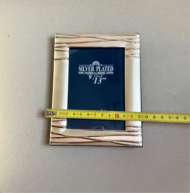 Marco de fotos plateado.
Medida 13cmX 9cm