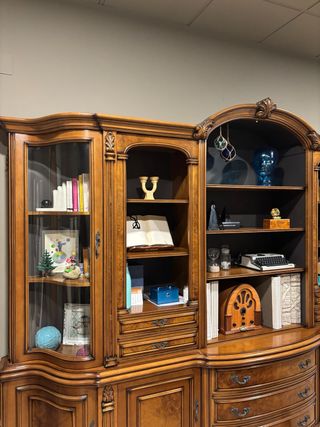 Mueble de madera maciza y cristal curvo.