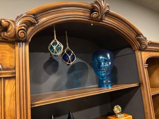 Mueble de madera maciza y cristal curvo.