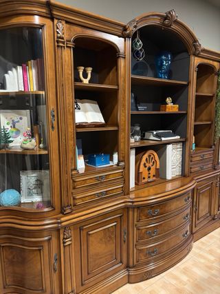 Mueble de madera maciza y cristal curvo.