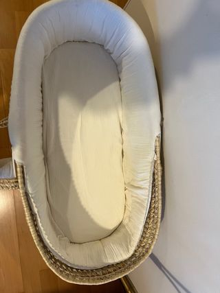 Moisés de mimbre con vestiduras beige.