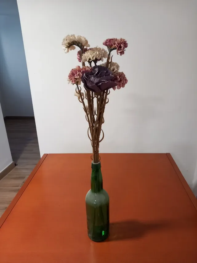 Botella verde con flores secas