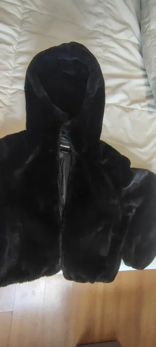 Chaqueta peluda negra con capucha.
