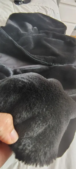 Chaqueta peluda negra con capucha.
