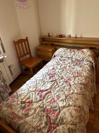 Cama individual de madera con colcha floral