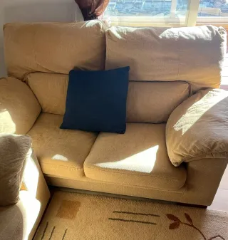 Los dos Sofás de tela beige con cojines azules