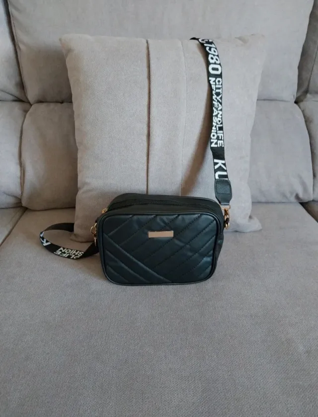 Bolso negro acolchado con correa de letras