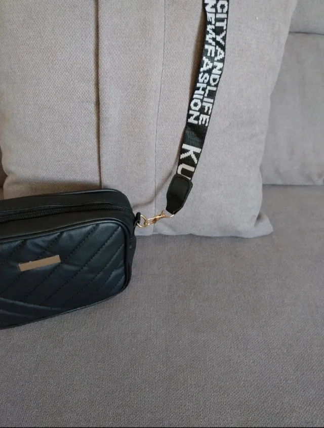 Bolso negro acolchado con correa de letras