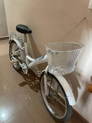 Bicicleta blanca con cesta y portaequipajes