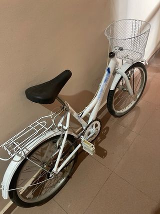 Bicicleta blanca con cesta y portaequipajes