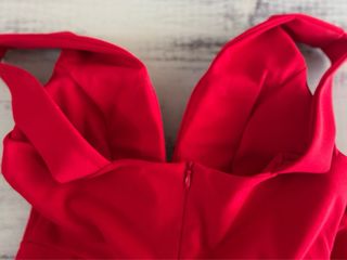 Vestido rojo escotado con falda plisada.