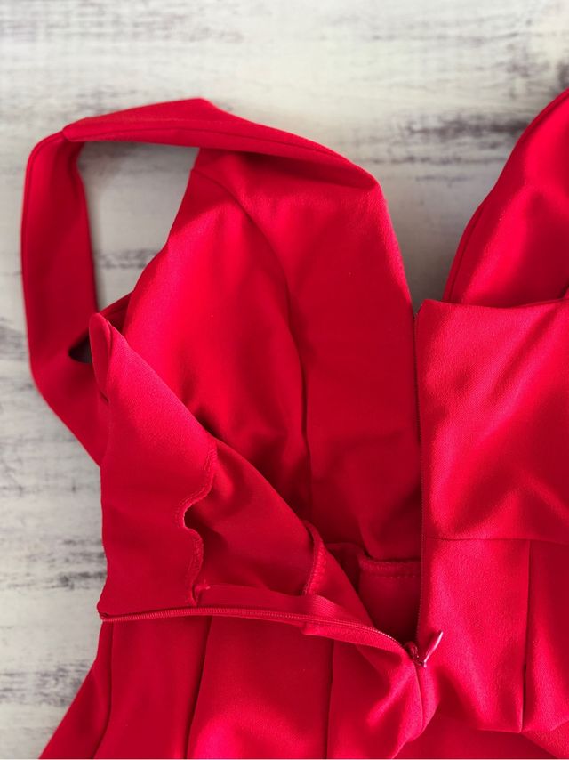 Vestido rojo escotado con falda plisada.