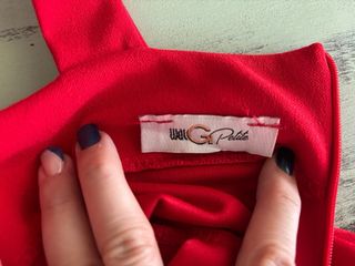 Vestido rojo escotado con falda plisada.