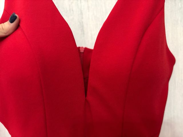 Vestido rojo escotado con falda plisada.