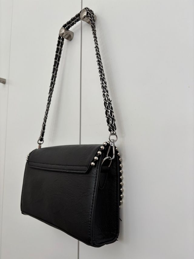 Bolso negro con tachuelas y cadena