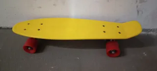 Monopatín amarillo con ruedas rojas