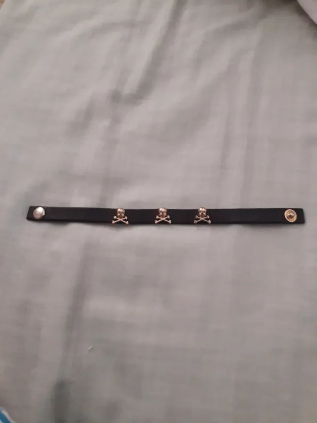 Bracciale in pelle nera con teschi dorati