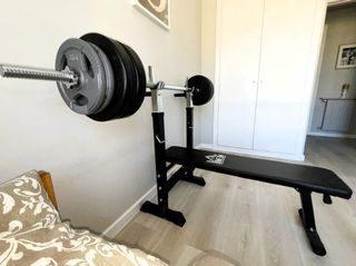 Banco de pesas con barra y discos distintos