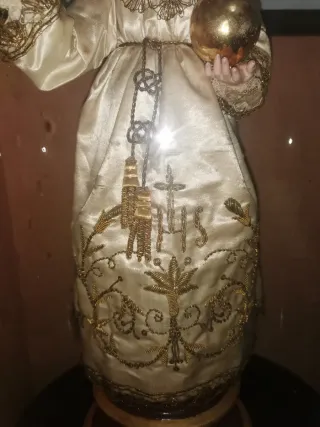 Muñeco en urna con detalles dorados