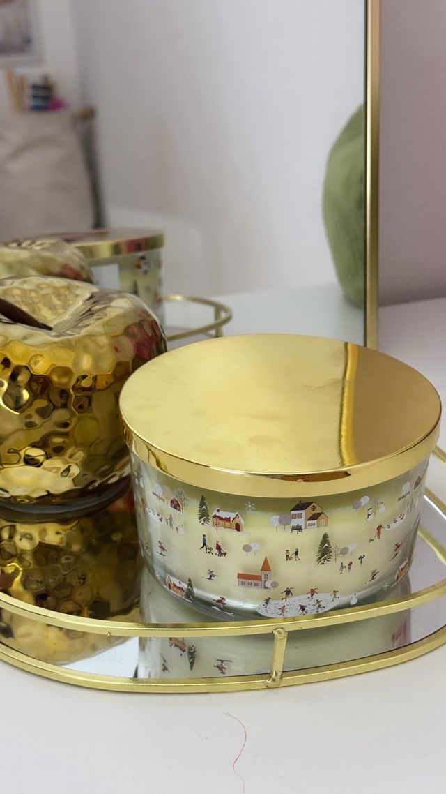 Candela decorativa dorada con diseño invernal