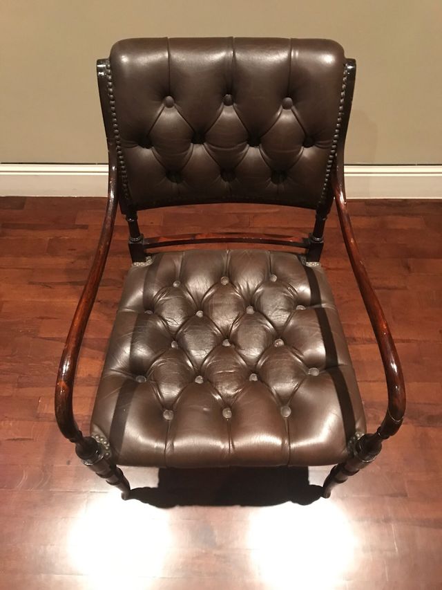 Sillón de piel verde y madera marrón