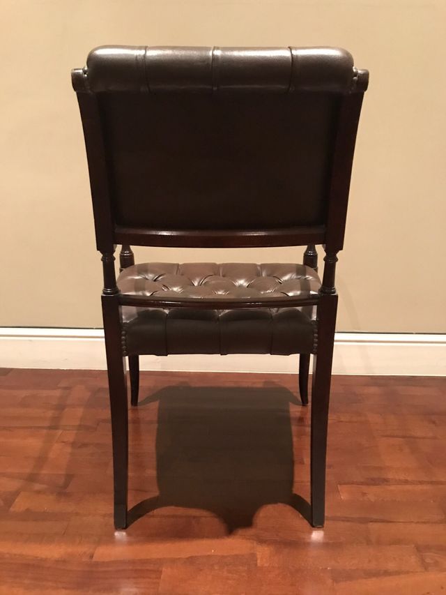 Sillón de piel verde y madera marrón