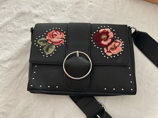 Bolso negro con flores bordadas.