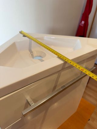 Mueble de baño pequeño con lavabo y grifo.