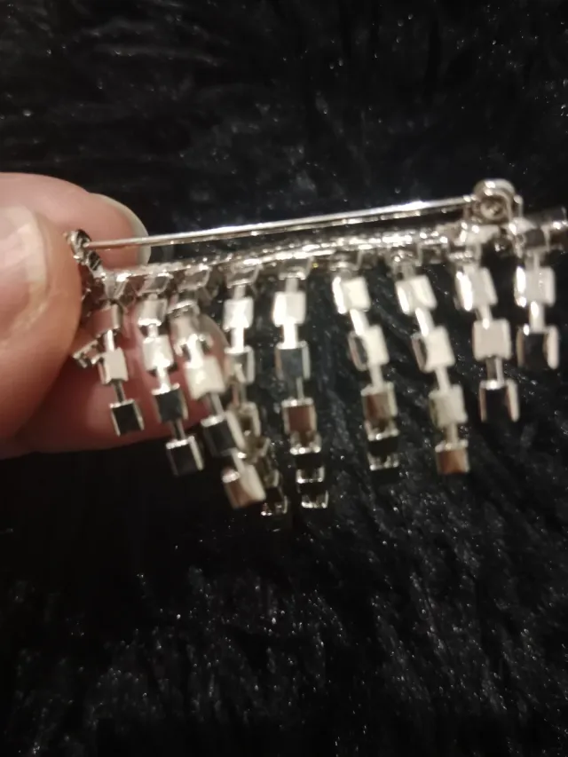 Broche plateado con pedrería