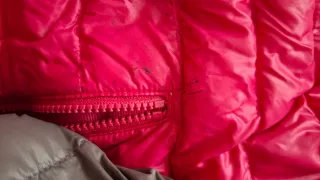 Plumífero Trango gris y rojo. Pequeñas manchas del