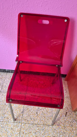 Silla roja transparente de plástico y metal
