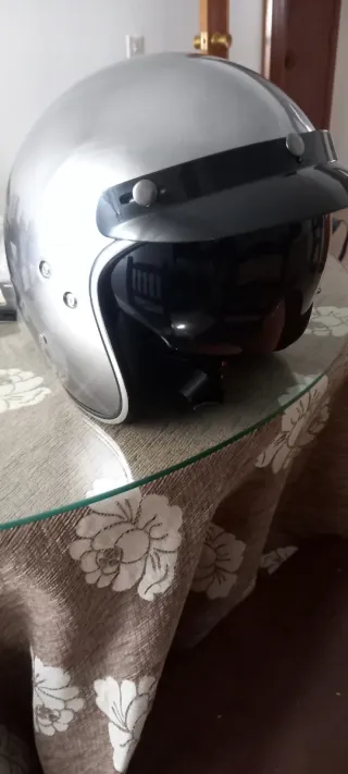 Casco de moto plateado con visera