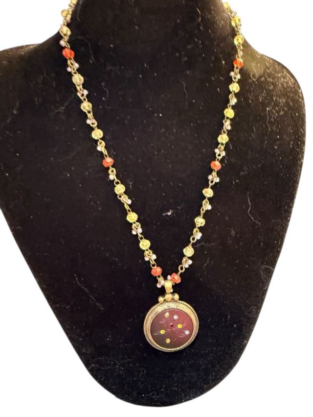 Collar con colgante dorado y piedras