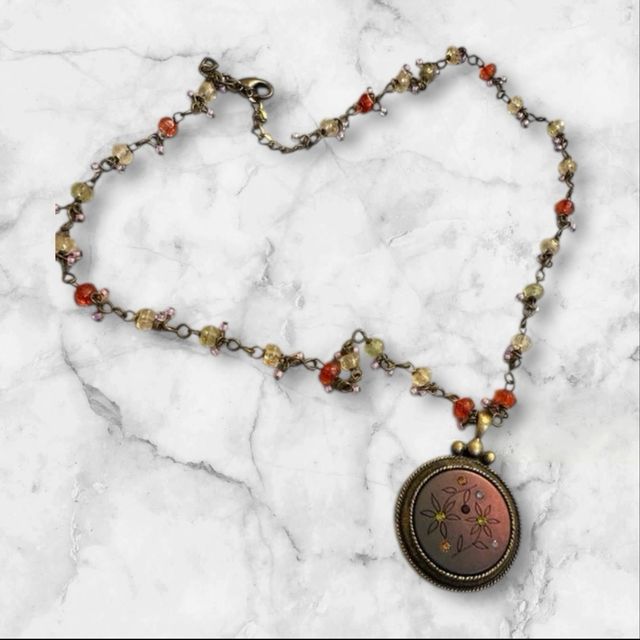 Collar con colgante dorado y piedras