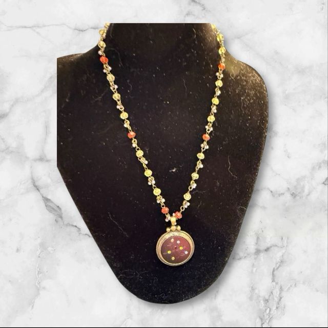 Collar con colgante dorado y piedras