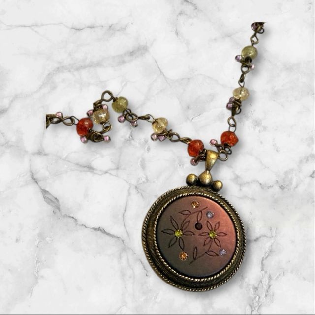 Collar con colgante dorado y piedras