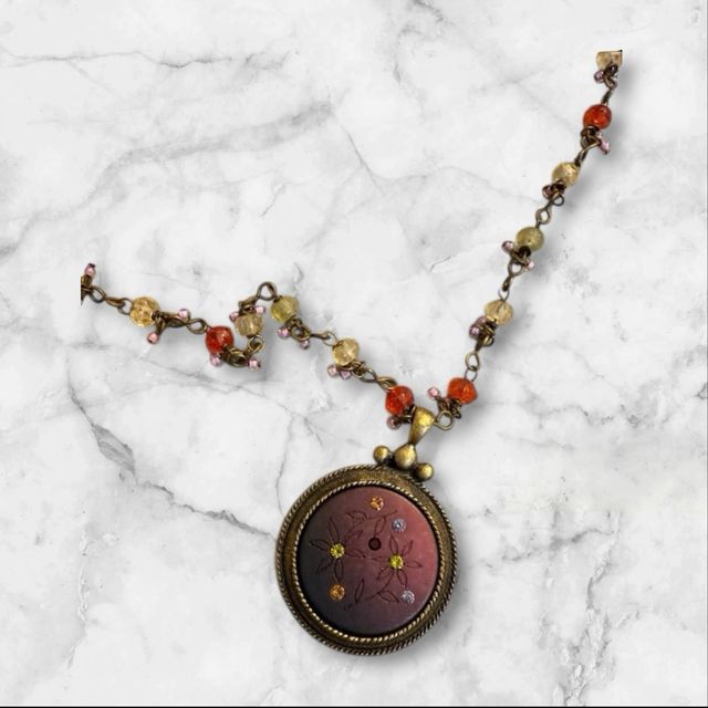 Collar con colgante dorado y piedras