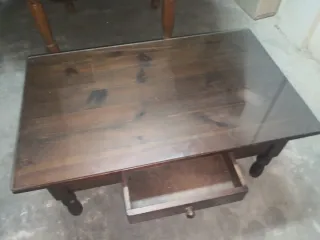 Mesa baja de madera con cajón y cristal.