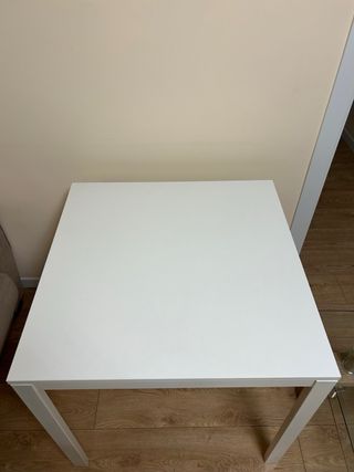 Mesa blanca de madera y carcasa de hierro.