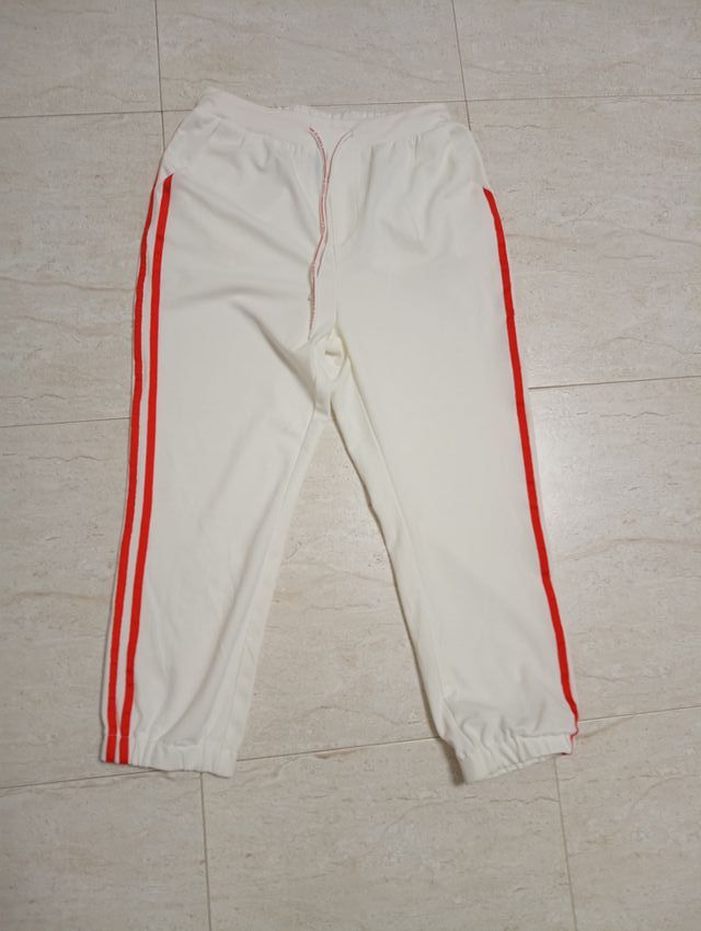 Pantalones deportivos blancos con rayas rojas