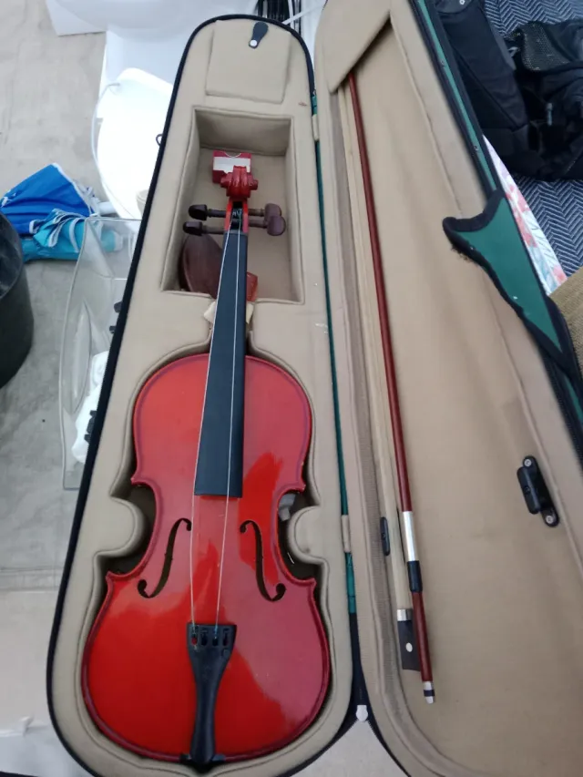 Violín rojo con arco y estuche