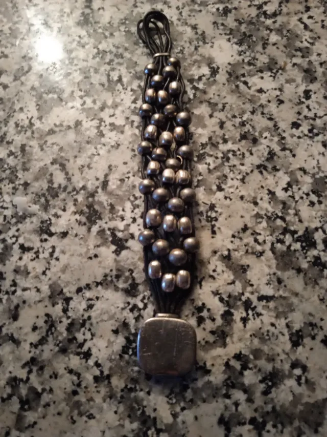 Pulsera de cuentas plateadas y cordón negro