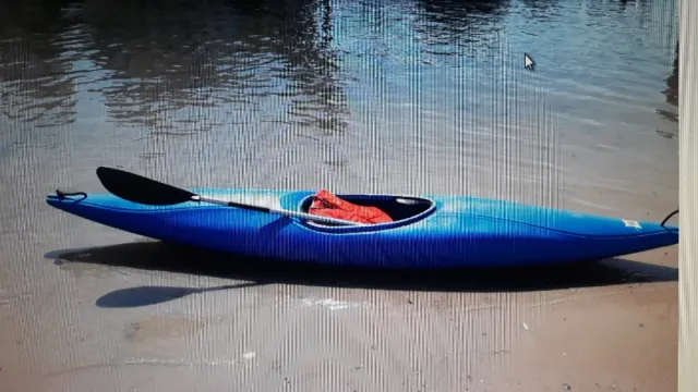 Piragua azul con remo y chaleco salvavidas