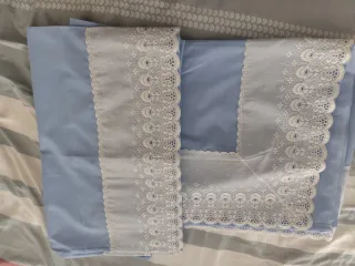 Sábana encimera y aa lmohadón azul con encaje blan
