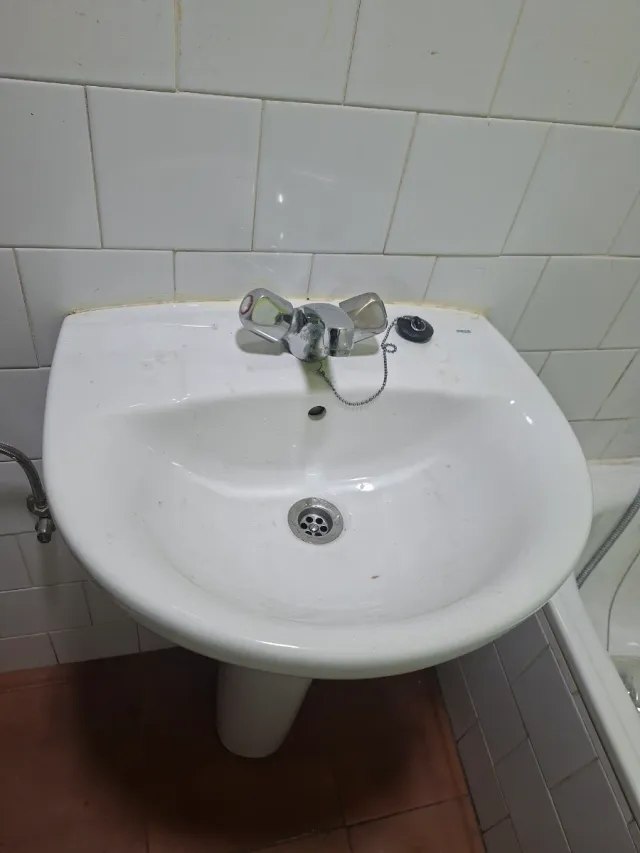 Lavabo de cerámica con grifo de metal