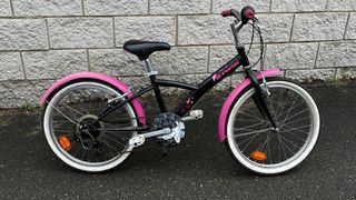 Bicicleta niña Decathlon rosa y negra.