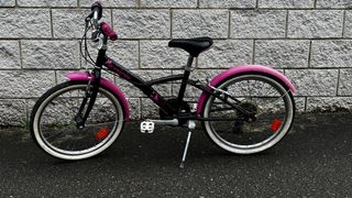 Bicicleta niña Decathlon rosa y negra.