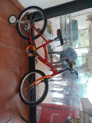 Bicicleta infantil roja con ruedines